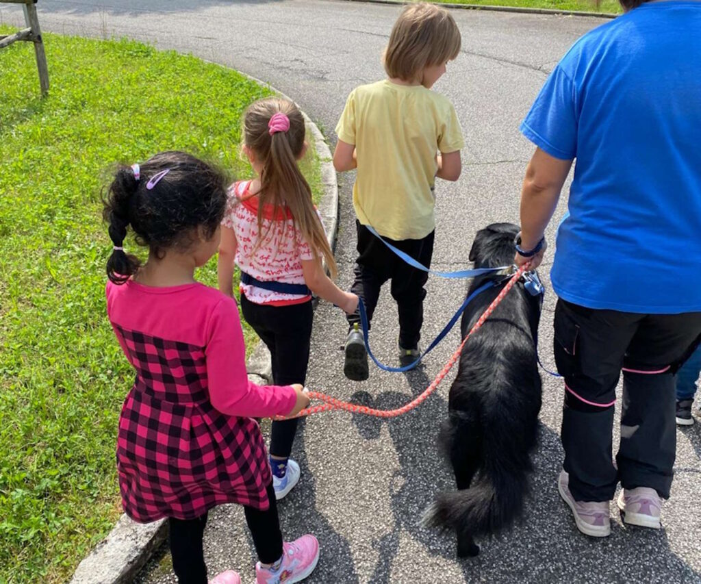 percorsi ludici con i cani presso La Nostra Famiglia di Pasian di Prato Udine. i bambini passeggiano con un cane al guinzaglio